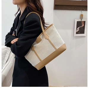 Vue détaillée du sac cabas en toile contrastée avec coutures en cuir marron et sangle