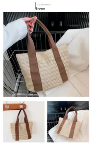 Detail of hand-woven straw tote bag with brown canvas straps and herringbone pattern