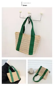 Detail of woven straw tote bag featuring contrast green ribbon handles in a lifestyle setting