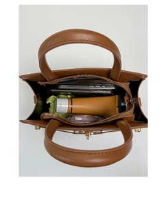 Top view of brown leather bag interior showing spacious storage for phone and cosmetics
