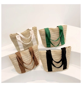 Detail view of woven straw tote bags with colorful handles in white green brown and black