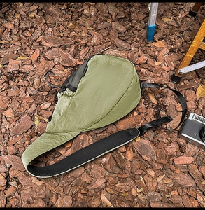Olive green nylon crossbody bag detail with mesh pocket and adjustable strap