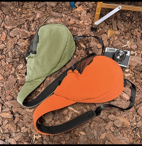 Detail of lightweight nylon sling bags in green and orange with mesh side panels