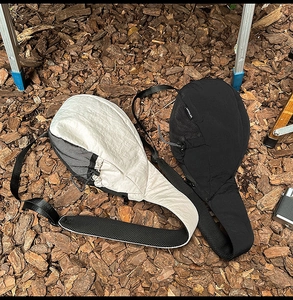 Outdoor shot of cream and black crossbody bags with mesh pockets on wood texture
