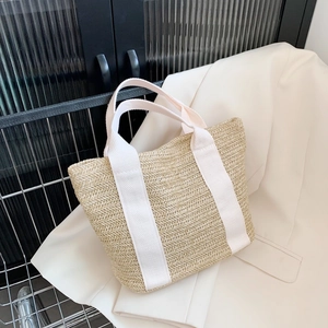 Handwoven straw tote bag with cream canvas straps for summer beach vacations