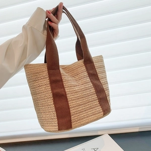 Handmade woven straw tote bag with brown ribbon handles for summer beach vacations