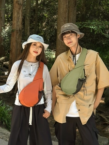 Outdoor crossbody chest bag with adjustable strap and bucket hat set in a forest scene