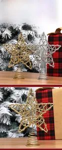 Close-up of glittery gold and silver wire Christmas tree star toppers on snowy tree