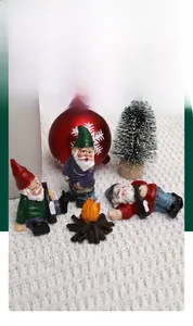 Close-up of funny resin garden gnomes sitting around a campfire for holiday decoration