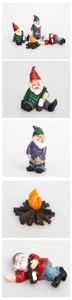 Macro detail of funny drunken garden gnomes figurines set with a campfire prop