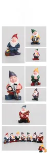 Detailed macro view of seven colorful resin garden gnomes with welcome sign and tools