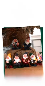 Detailed set of seven colorful resin garden gnomes holding various miniature tools