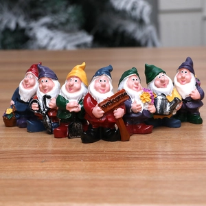 Set of seven colorful resin garden gnomes holding various tools on a wooden surface