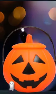 Close-up of orange Halloween pumpkin bucket with black handle and carved smiling face