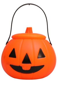 Detail of orange Halloween pumpkin candy bucket with black handle and carved smile face