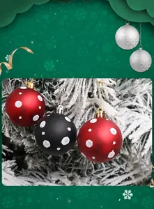 Detalle de bolas de Navidad rojas y negras con copos de nieve en rama de árbol