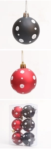 Detalle de bolas de Navidad rojas y negras con puntos de purpurina blanca y cuerdas