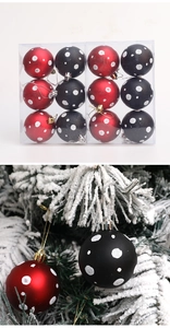 Detalle de bolas de Navidad mate rojas y negras con lunares blancos en un árbol