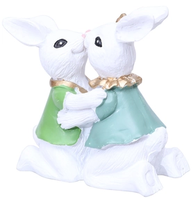 Macro detail of Easter kissing bunny resin figurines showing textured fur and gold collars
