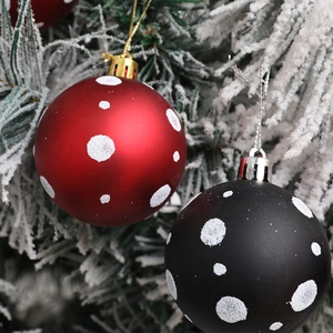 Bolas de Navidad de 6cm rojas y negras con lunares sobre ramas de árbol nevadas