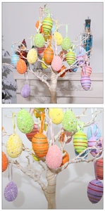 Detailopname van kleurrijke gestreepte paaseieren met glitters hangend aan een witte boom
