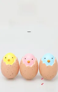 Dettaglio di tre ciondoli colorati a forma di uovo di Pasqua in resina gialla e rosa