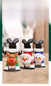 Close-up of three festive wind-up toys showing Santa, Snowman and Reindeer in handstand pose