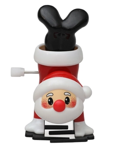 Macro detail of hand-cranked wind-up Santa toy with mechanical walking mechanism