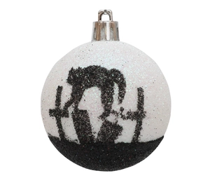 Detail of white Halloween bauble with glitter and black sequined cat on cemetery silhouette