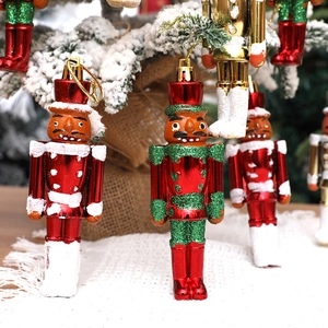 Rote und grüne Nussknacker-Soldaten Anhänger an einem verschneiten Weihnachtsbaum