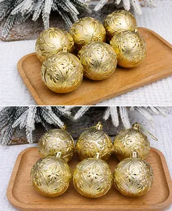Détail de boules de Noël dorées de 6cm avec motifs floraux gaufrés et attaches incluses