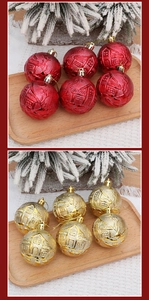 Détail de boules de Noël de 6cm rouges et dorées avec motifs nordiques en relief