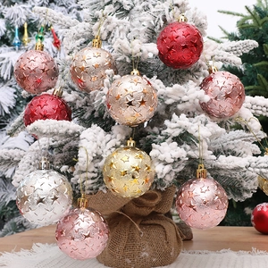 Embossed star Christmas ball ornaments in assorted colors hanging on a snow-covered tree