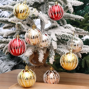 Set dekorative Weihnachtskugeln mit Wellenmuster hängend an einem verschneiten Baum