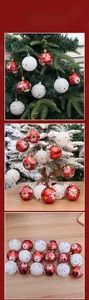 Close-up of red and white Christmas balls with snowflake patterns on a tree branch