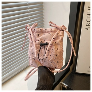 Detailed shot of pink quilted canvas tote with black bow pattern and drawstring closure