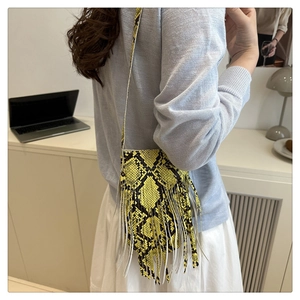 Close-up of yellow and black snake print shoulder bag with long bohemian tassels