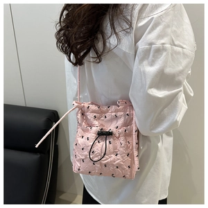 Detail of pink quilted tote bag showing bow patterns and functional drawstring closure