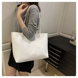 Detail of white woven tote bag with FASHION label and textured grid pattern
