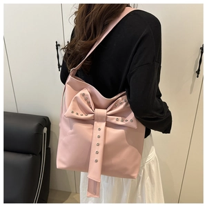 Close-up of pink tote bag featuring a large bow with silver rhinestones and smooth PU leather