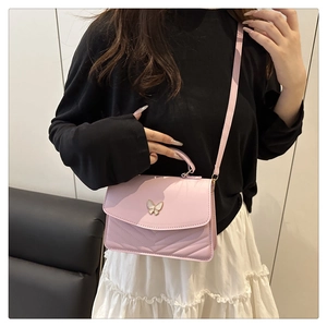 Detail of pink chevron quilted handbag with butterfly metal clasp and crossbody strap