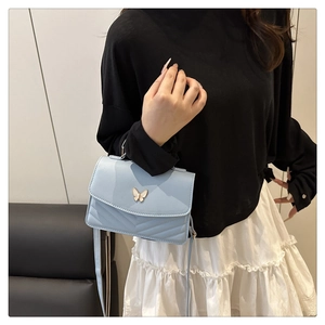 Light blue crossbody bag with gold butterfly buckle and elegant V-shaped quilting detail