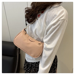 Detail of pink lychee texture shoulder bag with decorative chain and fashion text