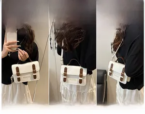Three-way carry demonstration of white leather crossbody bag with brown flap buckle