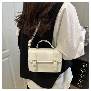 Modern white mini crossbody bag shown on model highlighting compact size and chic style