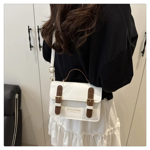 Macro view of white PU leather crossbody bag featuring gold hardware and brown handle