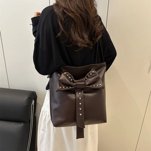 Dark brown PU leather shoulder bag featuring a large bow and silver stud embellishments