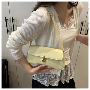 Detail view of cream shoulder bag with golden twist lock and adjustable slim strap