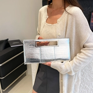 Silver crocodile texture handbag with metal top handle shown on fashion model