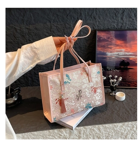 Detailed embroidery on pink tote bag featuring butterfly and traditional cloud motifs